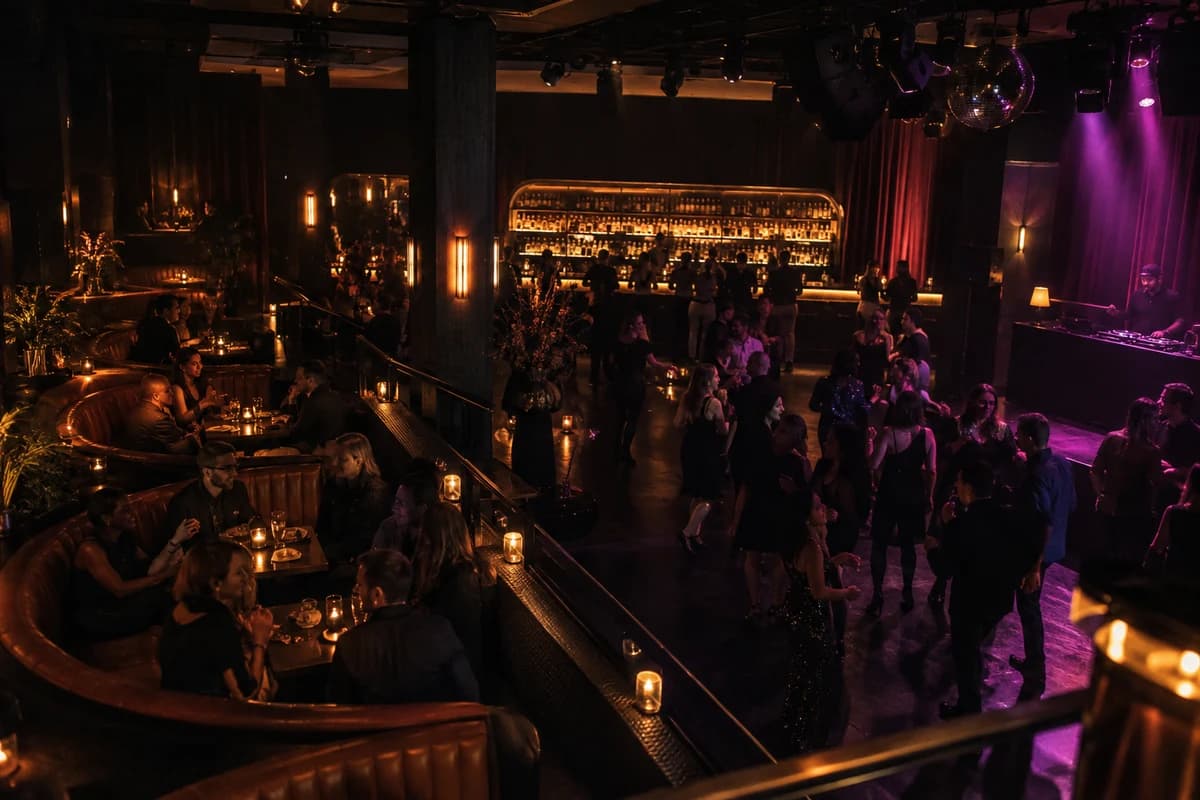 An elevated view of a nightclub with occupied table seating beside a lively dance floor