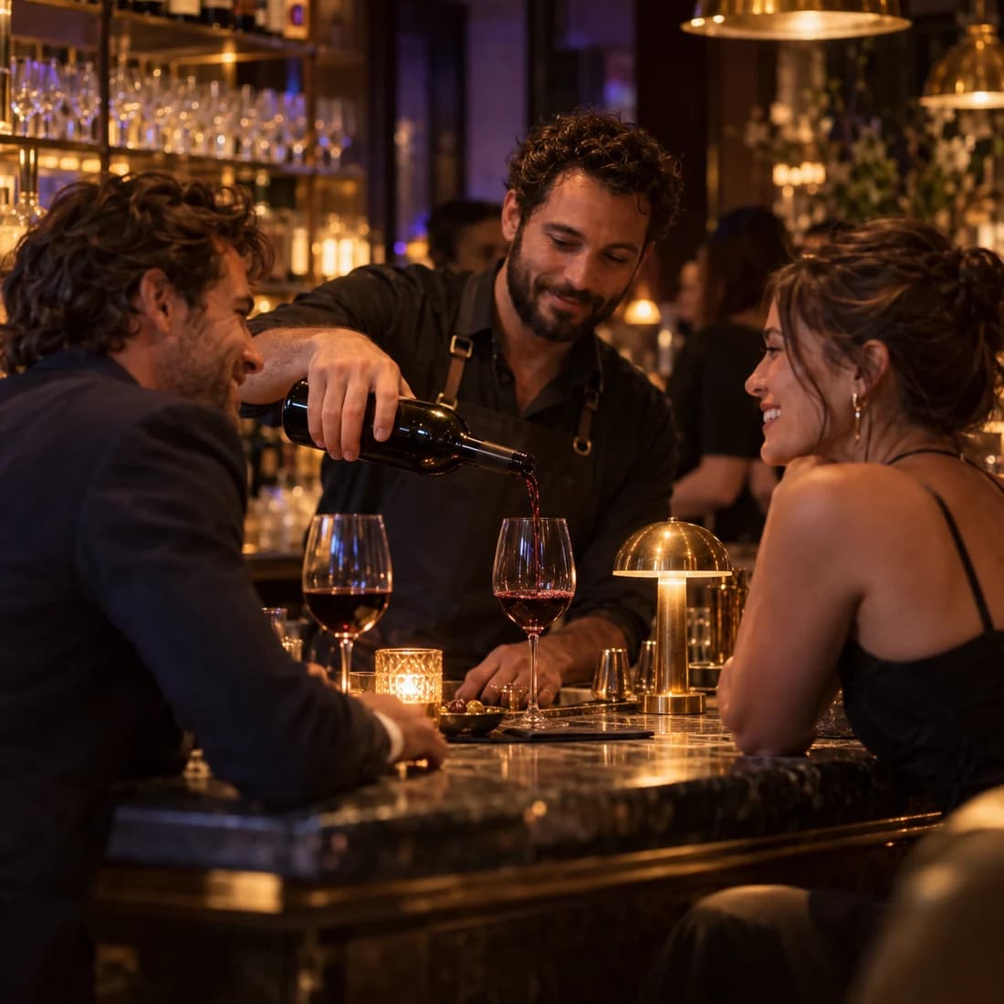 A server pours wine for a smiling group at a lounge table