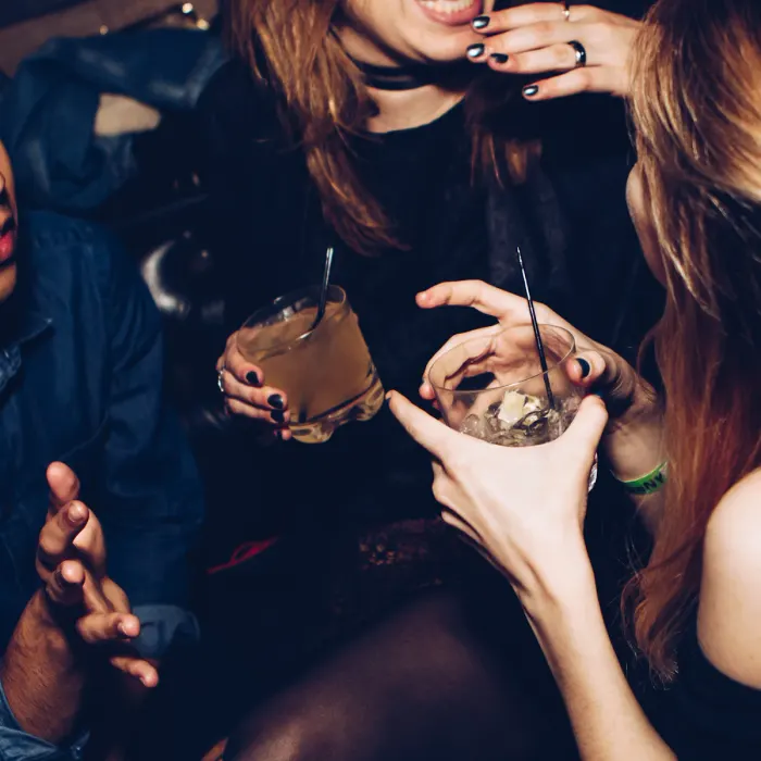 Friends raise their drinks together on a night out